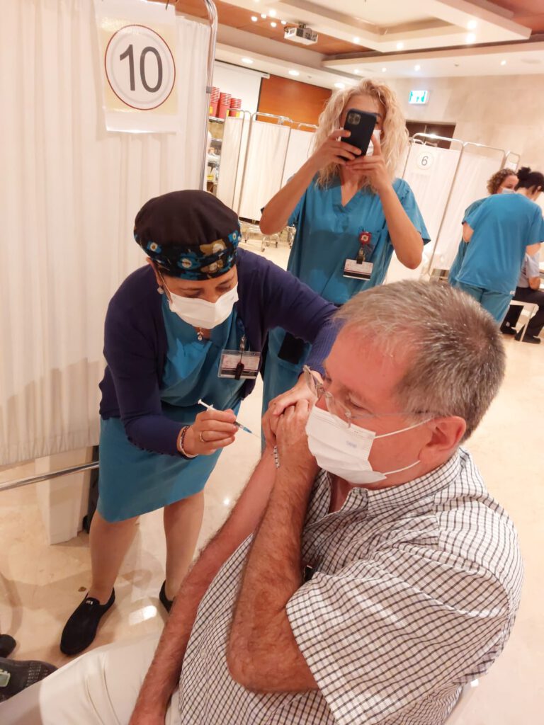 בתמונה: ד"ר מיקי הלברטל מקבל את זריקת החיסון השלישית מידה של האחות מיכל קרנצלר קרדיט: דוברות הקריה הרפואית רמב"ם