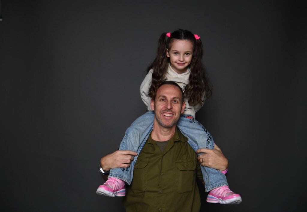 סא"ל (במיל') צפיר, תושב חיפה המשרת במילואים מאז פרוץ המלחמה, בצילום יחד עם בתו, עלמא, מתוך קמפיין ההוקרה שיזמה עיריית חיפה למען חיילי המילואים. קרדיט צילום: ראובן כהן, דוברות עיריית חיפה