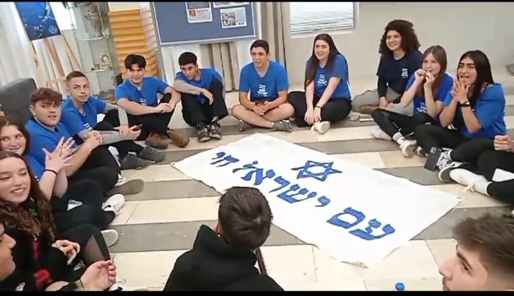 ביקור מרגש במרכז היום: משתתפי "המסע הישראלי" הפיחו תקווה חדשה ואפילו שמחה בני נוער המשתתפים בתוכנית שמטרתה הענקת זהות ישראלית משמעותית הגיעו לבית הספרדי ∙ המפגש עם האוכלוסייה הוותיקה הוליד רגעים מרגשים וגם משמחים ∙ האירוע כלל שיחות מגוונות, מעגל שירה וריקודים אירועי שמחת תורה, והמלחמה שפרצה בעקבותיהם, מובילים באופן טבעי לתחושות מורכבות וקשות אצל רוב אזרחי ישראל. בימים שבהם החדשות קשות חשוב יותר מתמיד לשמור על חוסן רגשי, בין השאר באמצעות פעילויות שמפיחות תקווה ומזכירות לכולנו שיש גם יופי במציאות חיינו. אירוע שכזה היה הביקור של משתתפי "המסע הישראלי" במרכז היום של הבית הספרדי. המסע הישראלי הוא תוכנית חינוכית ייחודית של ארגון בעל אותו שם, שבראשו עומד האלוף במיל' אליעזר שקדי. מטרת התוכנית היא העמקת החיבור של בני נוער וחיילים לישראל ובמקביל העצמת ערכים אוניברסליים כגון מעורבות חברתית והכרה בפלורליזם. יישום החזון מושג באמצעות מסע בכל רחבי הארץ ומפגשים עם אוכלוסיות מגוונות. אחת התחנות שנבחרה למסע הייתה מרכז היום של הבית הספרדי. התוצאה: מפגש בין דורי מעצים עבור שני הצדדים. המשתתפים הצעירים הצטרפו למבקרים הוותיקים של מרכז היום למעגל שירה, כולם רקדו יחד בשמחה ולאחר מכן התנהלו גם שיחות ערות על החיים בישראל. המפגש הפיח תקווה חדשה בקרב נשות ואנשי מרכז היום, והעלה את המורל גם אצל בני הנוער וגם אצל בני ובנות הגיל השלישי.